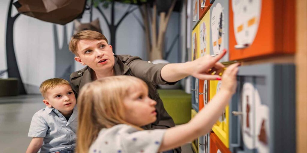 Mother Playing Discovery Games with Two Kids in Museum