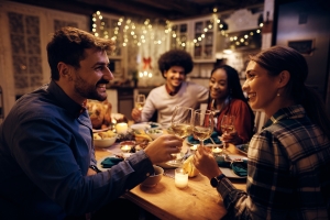 Happy Couple Toasting with Wine During Thanksgiving Dinner with Friends