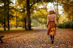 Young Woman Enjoying Fall Foliage Walk with Yellow Leaves