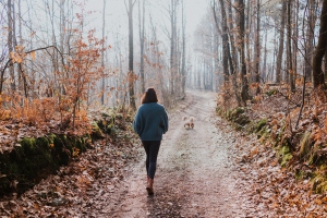 Girl Walking in Nature with Her Pet in Winter